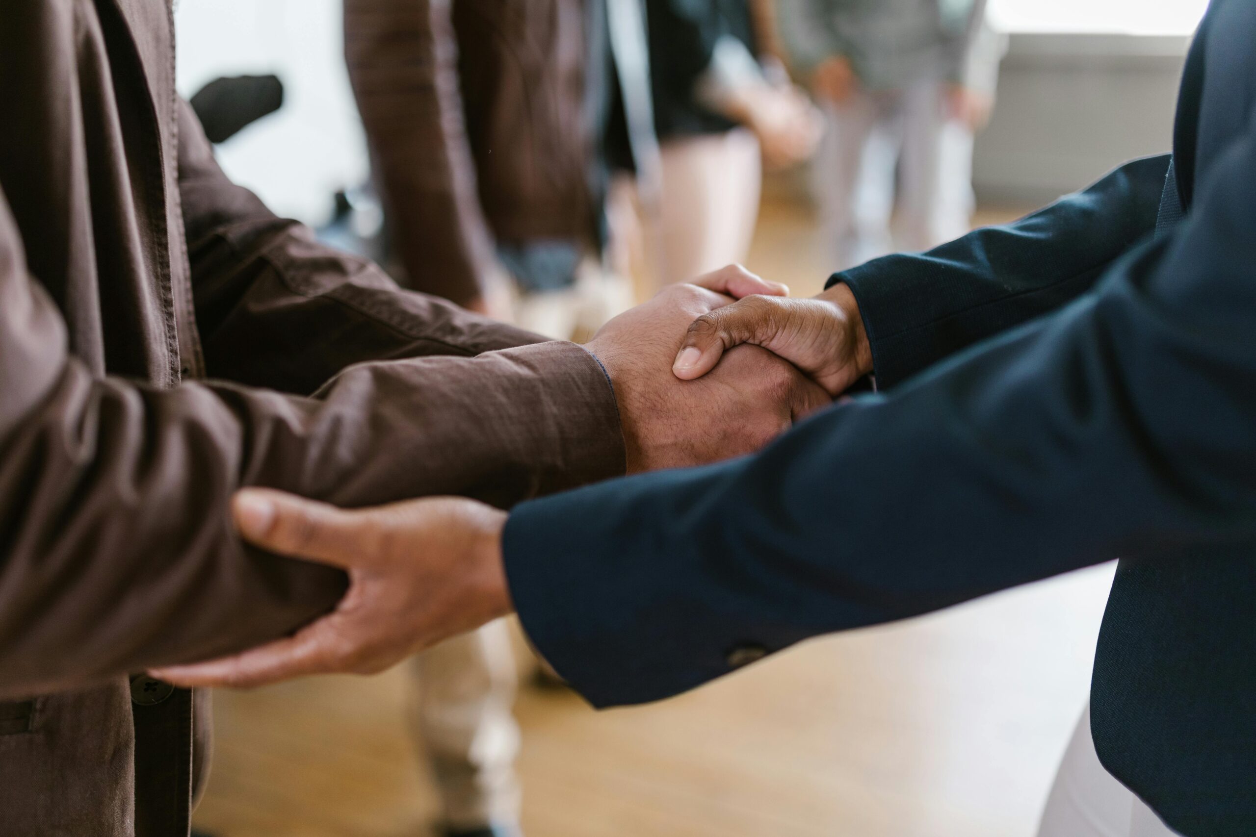 Close-up of two businesspeople shaking hands, symbolizing agreement and partnership.